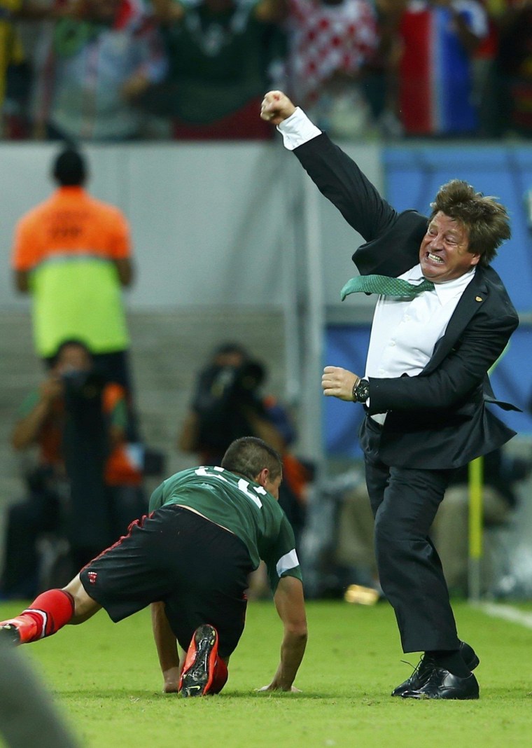 Image: Mexico's coach Miguel Herrera (R) celebrates the goal of Andres Guardado (not pictured) during their 2014 World Cup Group A soccer match against Croatia at the Pernambuco arena in Recife