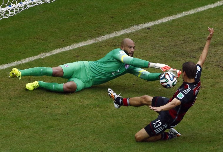 Germany's Mueller challenges goalkeeper Howard of the U.S. during their 2014 World Cup Group G soccer match at the Pernambuco arena in Recife