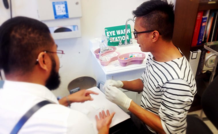 John Guigayoma (far right) gives an HIV test to a client at Asian & Pacific Islander Wellness Center in San Francisco.