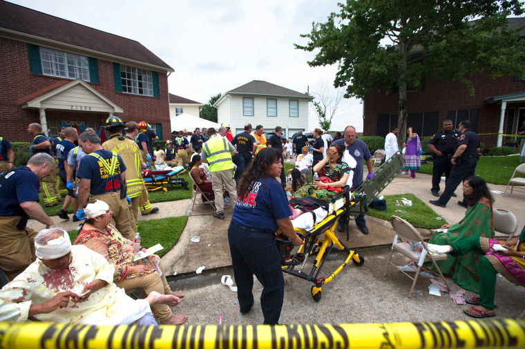 Image: Firefighters and emergency crews treated people outside in a makeshift triage area set up in the front yards of nearby homes after a floor collapsed under a large crowd of people gathered for a religious event in Katy, Texas