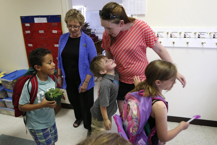 Image: Kindergartner Russell Emery, center, gives a hug to teacher's assistant Ashley Porter on the final day of school at the Wellington public school in Monticello, Maine