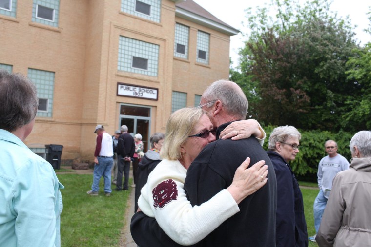 Image: Former members of the Cyrus elementary school community embrace during a reunion at the school in Cyrus, Minn.