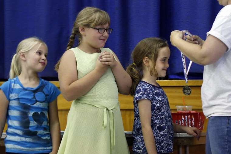 Image:Olivia Drake receives a medal for perfect attendance during an assembly on the final day of school at the Wellington public school in Monticello, Maine.