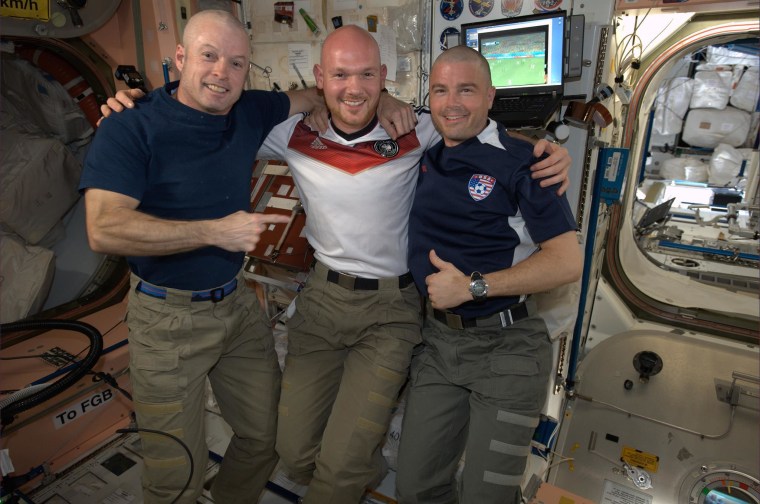 U.S. astronauts Steve Swanson and Reid Wiseman, right, show off their freshly-shaven heads after Gerst shaved them aboard the International Space Station