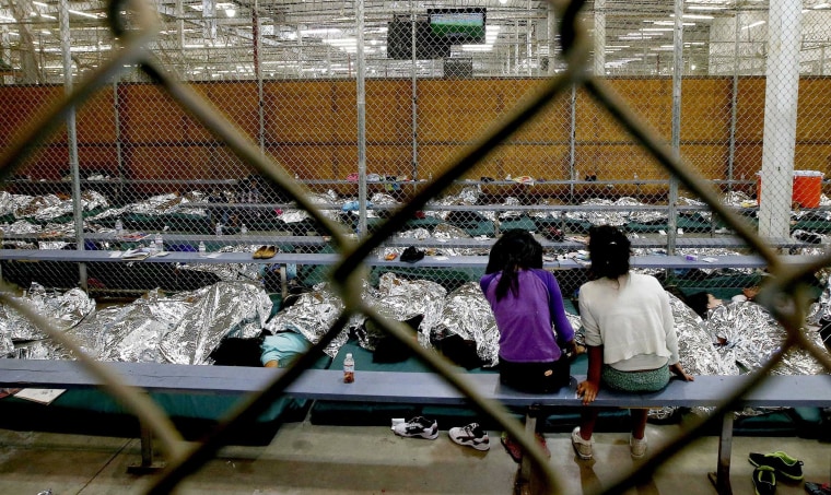 Image: Two young girls sit in their holding area at a U.S. Customs and Border Protection placementer center in Arizona.