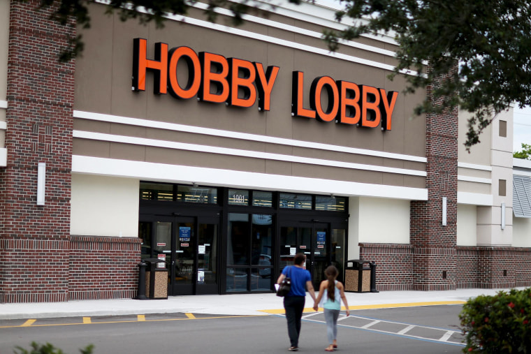 Image: People walk to a Hobby Lobby store in Plantation, Fla.