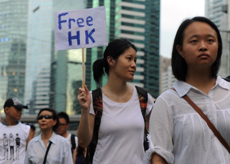 Image: A protester displays a placard during a pro-democracy rally seeking greater democracy in Hong Kong