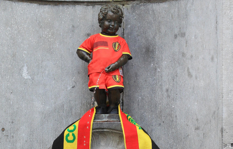 Image: A tourist takes a snapshot of Brussels iconic statue 'Manneken Pis'