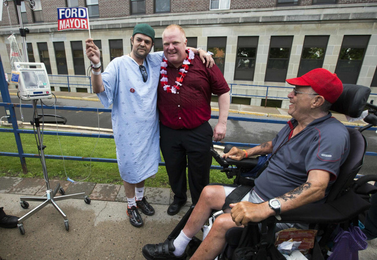 Image: Toronto Mayor Rob Ford poses with a hospital patient as he takes part in parade in his first public appearance since returning from a rehabilitation clinic in Toronto