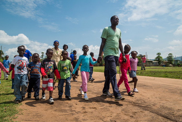 Image: Lale holds hands with children he has helped save.