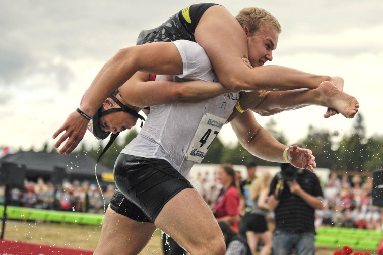 Image: Winning couple Ville Parviainen and Janette Oksman of Finland participate in the annual Wife Carrying World Championships in Sonkajaervi, Finland