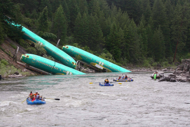 Image: Three Boeing 737 fuselages lie on an embankment on the Clark Fork River after a BNSF Railway Co train derailed near Rivulet