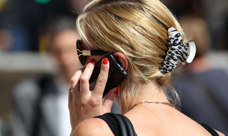 Image: A woman uses her cellphone in an airport on Aug. 26, 2013.