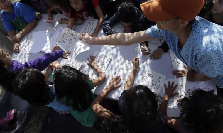 Image: Detainees color and draw at a U.S. Customs and Border Protection processing facility