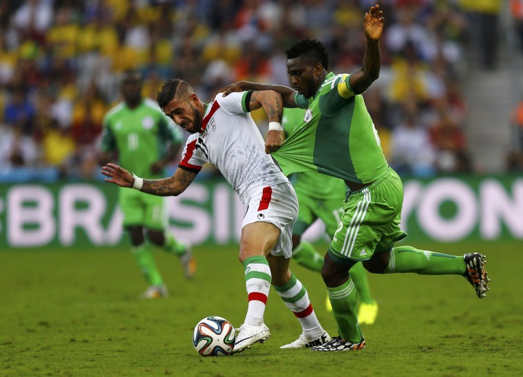 Image: Iran's Ashkan Dejagah fights for the ball with Nigeria's Joseph Yobo during their 2014 World Cup Group F soccer match at the Baixada arena