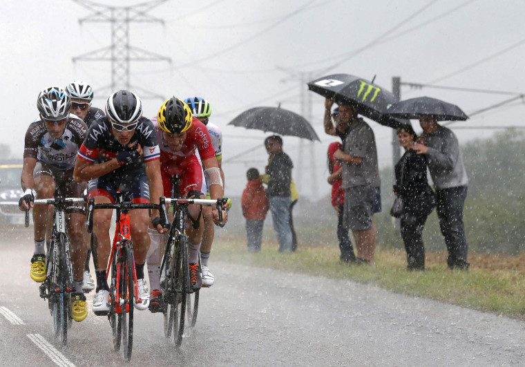 Image: A breakaway group of riders cycle during heavy rain falls during the 100 miles eighth stage of the Tour de France cycling race between Tomblaine and Gerardmer La Mauselaine