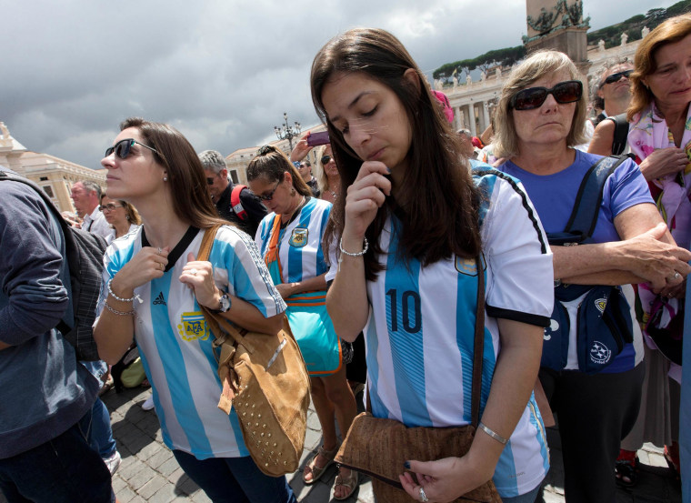 Image: Faithful wearing Argentina soccer team jerseys pray as Pope Francis delivers the Angelus praye