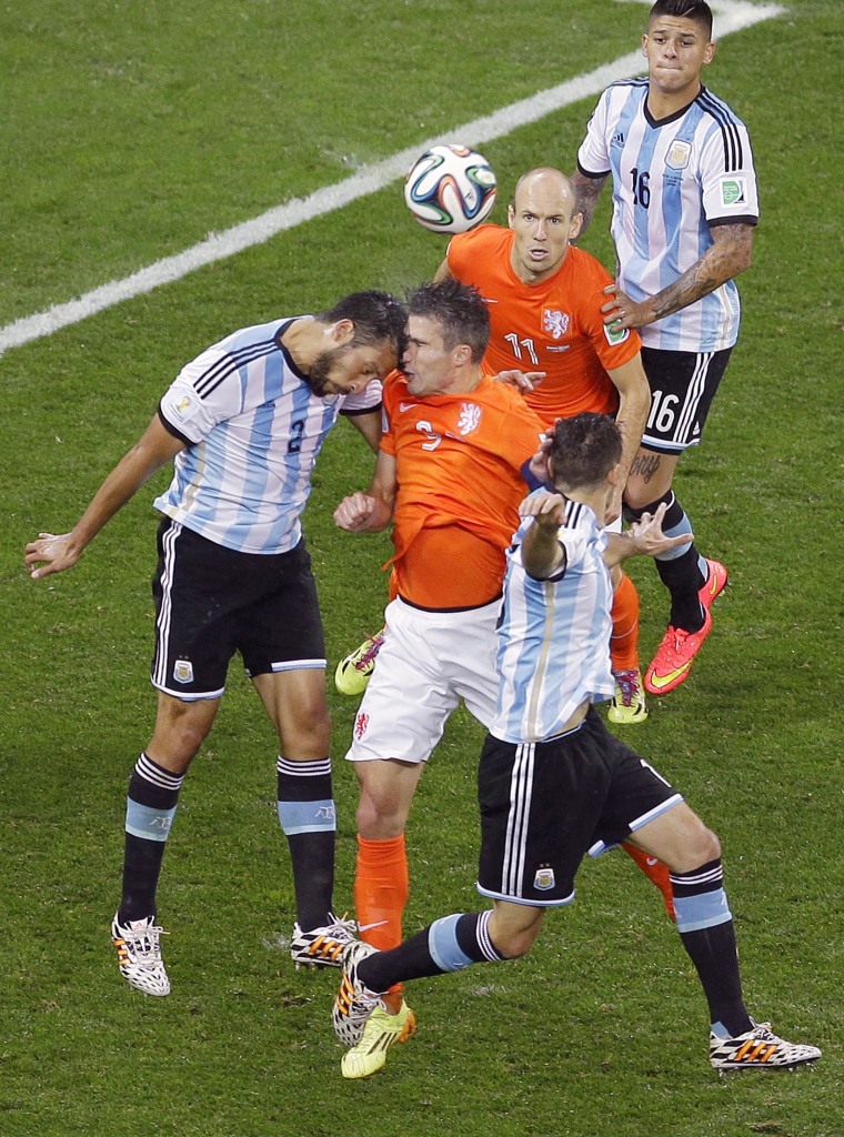 Argentina's Ezequiel Garay and Netherlands' Robin van Persie go for a header during the World Cup semifinal soccer match between the Netherlands and Argentina at the Itaquerao Stadium in Sao Paulo Brazil, on July 9. 