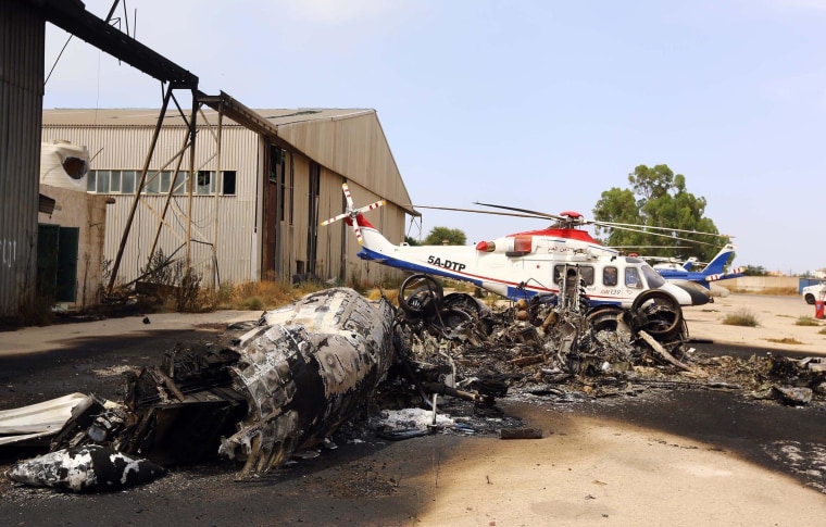 A charred airplane lies on the ground at Tripoli international airport in the Libyan capital on July 14, 2014 following fighting between rival armed groups. Islamist militias attacked the rival Zintan group that controls Libya's international airport in Tripoli yesterday, triggering fierce clashes that halted flights, officials said. 