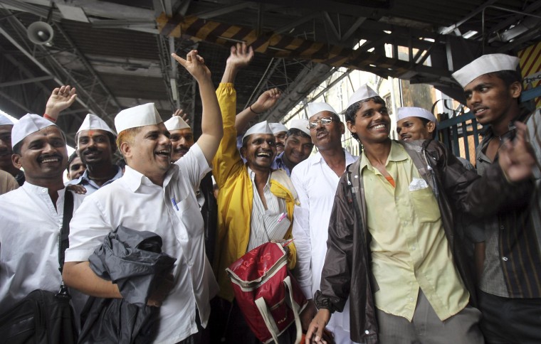 Image: Dabbawalas, or lunchbox delivery men, celebrate the birth of the Prince of Cambridge, the son of Britain's Prince William and Kate, Duchess of Cambridge, at a railway platform in Mumbai, India, on July 23, 2013