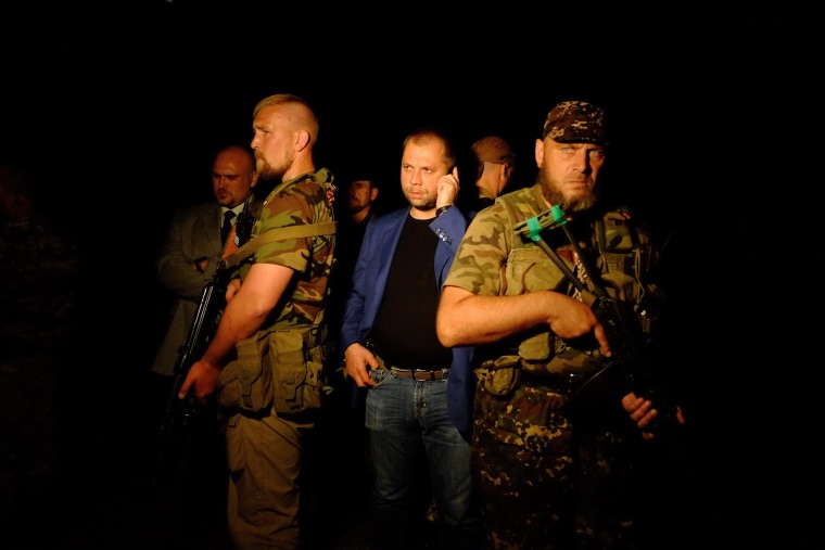 Image: Self-proclaimed Prime Minister of the pro-Russian separatist 'Donetsk People's Republic' Alexander Borodai, center, stands as he arrives on the site of the crash of a Malaysian airliner carrying 298 people from Amsterdam to Kuala Lumpur