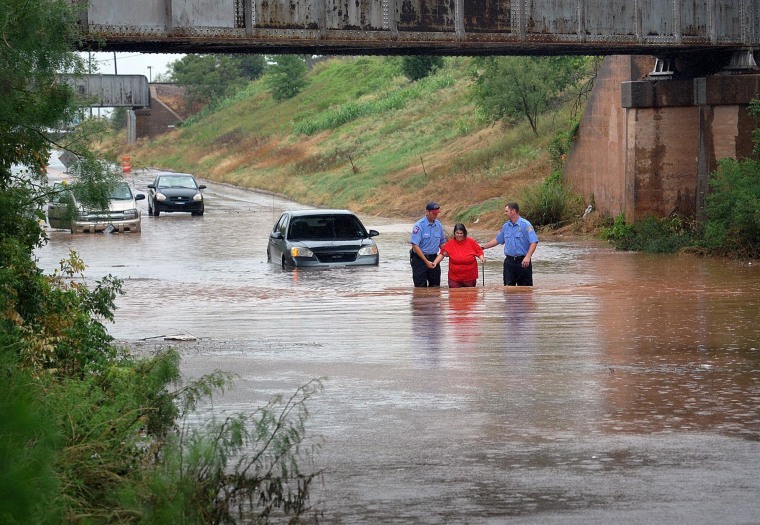 Image: Firefighters rescue a woman Thursday after her car stalled in high water in Wichita Falls, Texas.