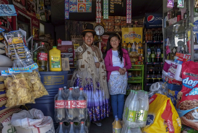 File photo of Lucia Mayta, 43, and her daughter Luz Cecilia, 12, posing for a photograph inside their bodega in La Paz, Bolivia, February 24, 2014. 