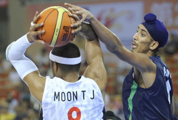 Image: Moon Tae Jong of South Korea passes a ball as Amjyot Singh of India defends during their preliminary round match between South Korea and India at the 26th Asian Basketball Championships in Wuhan in China's central Hubei province on Sept. 17, 2011.