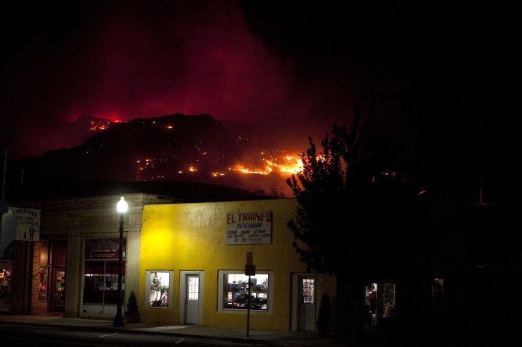 Image: A wildfire is seen raging in the hills behind Brewster, Wash.