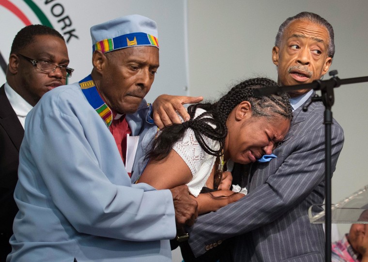 Image: Esaw Garner, center, wife of Eric Garner, breaks down in the arms of Rev. Herbert Daughtry and Rev. Al Sharpton