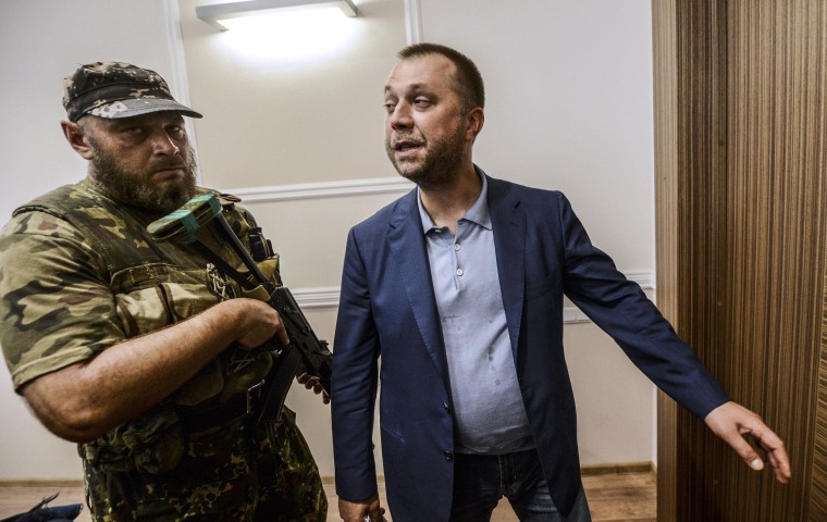 Image: Alexander Borodai stands next to pro-Russian separatist in military fatigues