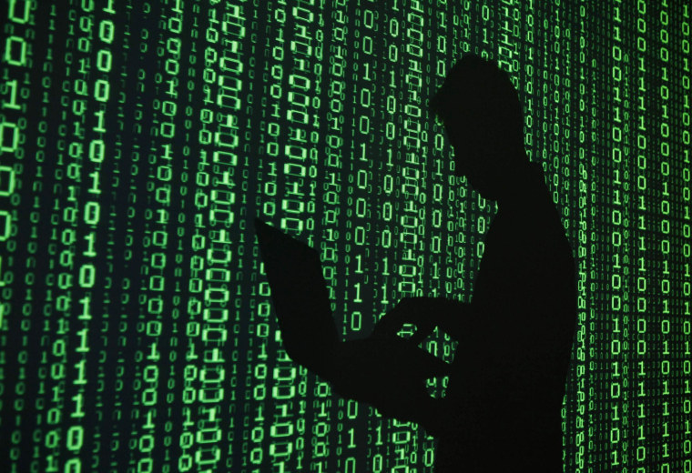 Image: Illustration of a projection of binary code around the shadow of a man holding a laptop computer