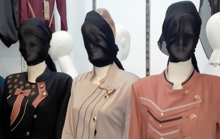 Image: Mannequins with their faces covered are displayed in a shop window in central Mosul