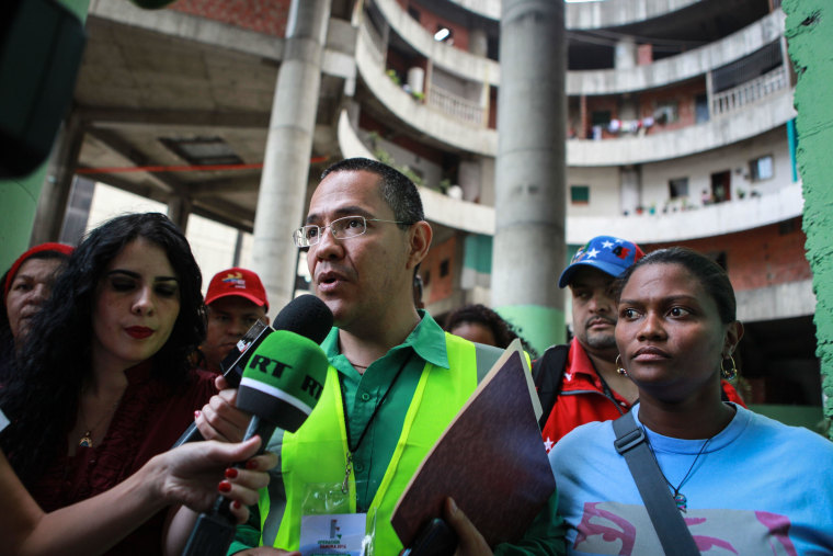 Image: The Minister of State for the Urban Transformation of Greater Caracas, Ernesto Villegas, speaks to the press during the eviction of the Tower of David