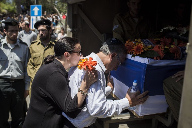 Image: The parents of Sergeant Max Steinberg grieve at his coffin