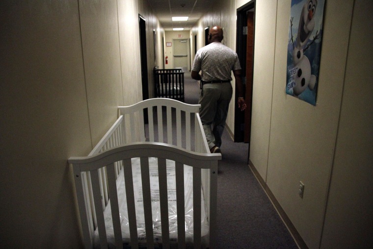 Image: A federal employee is seen walking past cribs inside of the barracks for law enforcement trainees turned into immigrant detention center at the Federal Law Enforcement Center (FLETC) in Artesia, N.M.