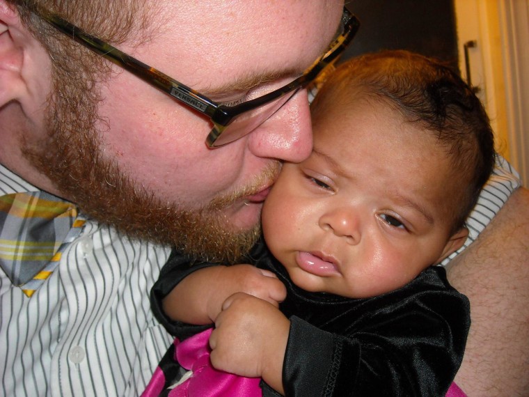 Seth Jackson holds the foster child, known as Anna and Kadylak, in a family photo. The 10-month-old died in Wichita, Kansas, after being left inside a hot car for two hours on a 90-degree day, police said Friday.