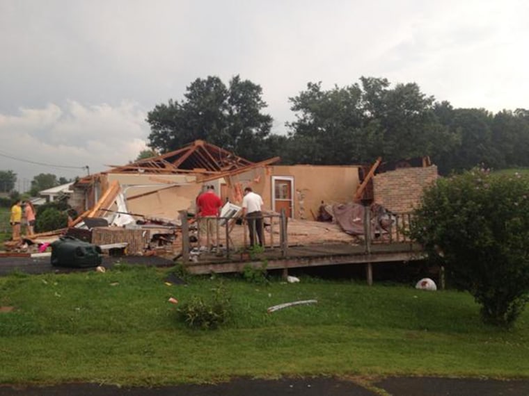Image: A family looks at their destroyed home after a tornado hit Kingsport, Tenn., on Sunday evening.