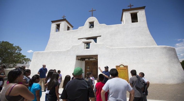 Image: Isleta Tribal Elder Max Zuni addresses students in front of the St. Augustine Church about their history and the importance of maintaining their native language.