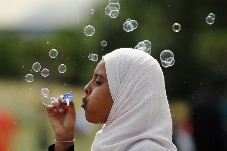 Image: A girl blows bubbles during an Eid celebration in Burgess Park