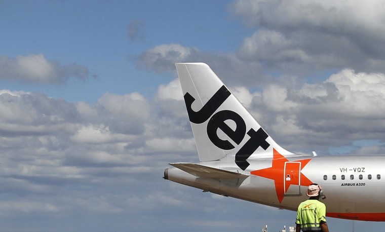 Image: An airport worker stands in front of a Jetstar passenger plane at Avalon Airport in Melbourne on March 19, 2010 .