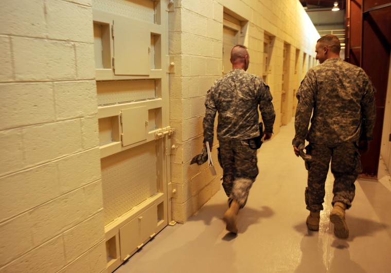 Image: U.S. soldiers walk past prison cells during a media tour of Bagram prison, north of Kabu