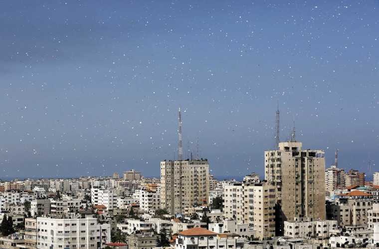 Image: Fliers are dropped over Gaza City by the Israeli army urging residents to evacuate their homes