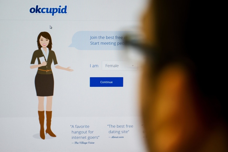 Image: In a photo illustration, a person looks at the OkCupid website.