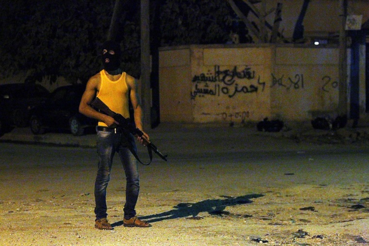 Image: A masked Libyan gunman stands on a street in the eastern city of Benghazi