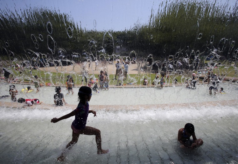 Image: Children run into a fountain during a heat wave at a park in Tokyo, on July 26.