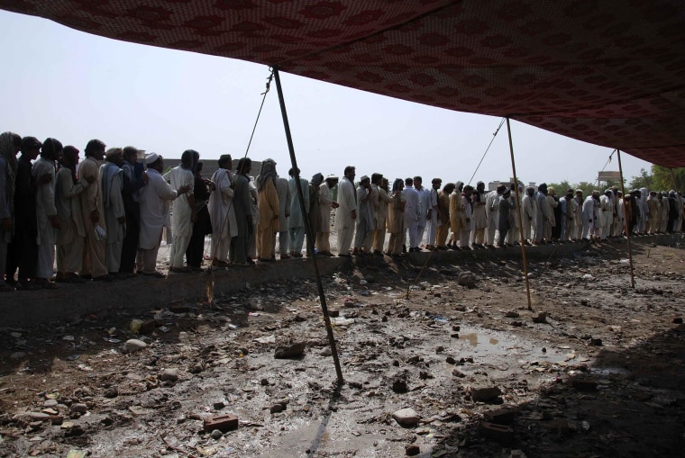 Image: Men fleeing military offensive in North Waziristan queue to get relief handouts in Bannu