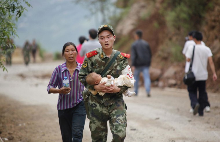 Image: A Chinese rescuer carries a baby after an earthquake hit an area in southwest China.