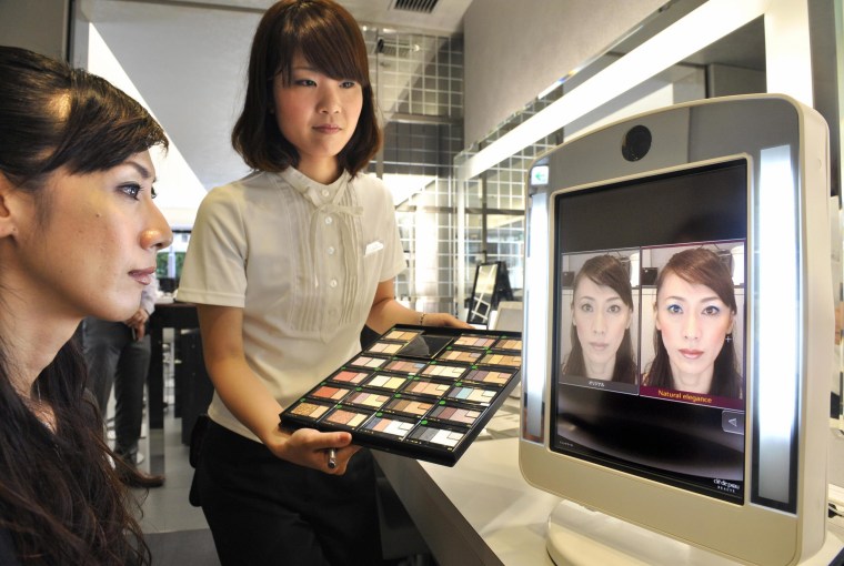 Image: An employee of Japan's cosmetics giant Shiseido demonstrates the company's virtual make-up system