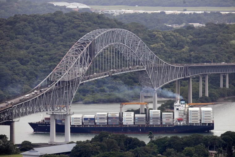 Image: A container ship sails underneath the Bridge of the Americas in the Panama Canal in Panama City